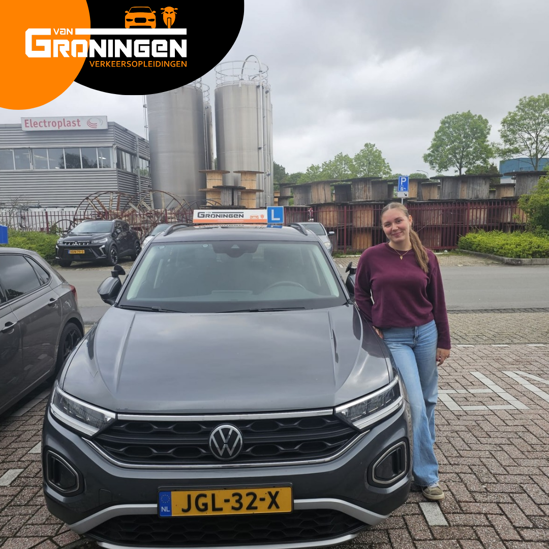 Geslaagde leerling naast de lesauto