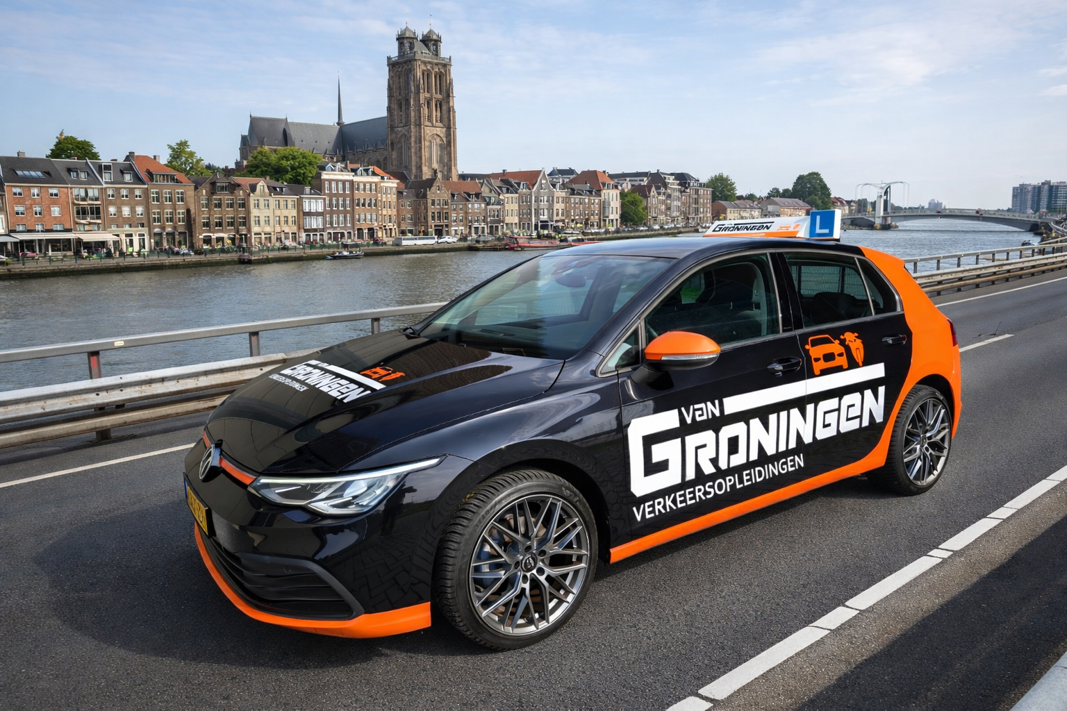 De zwart-oranje lesauto van Van Groningen Verkeersopleidingen op een brug bij Dordrecht