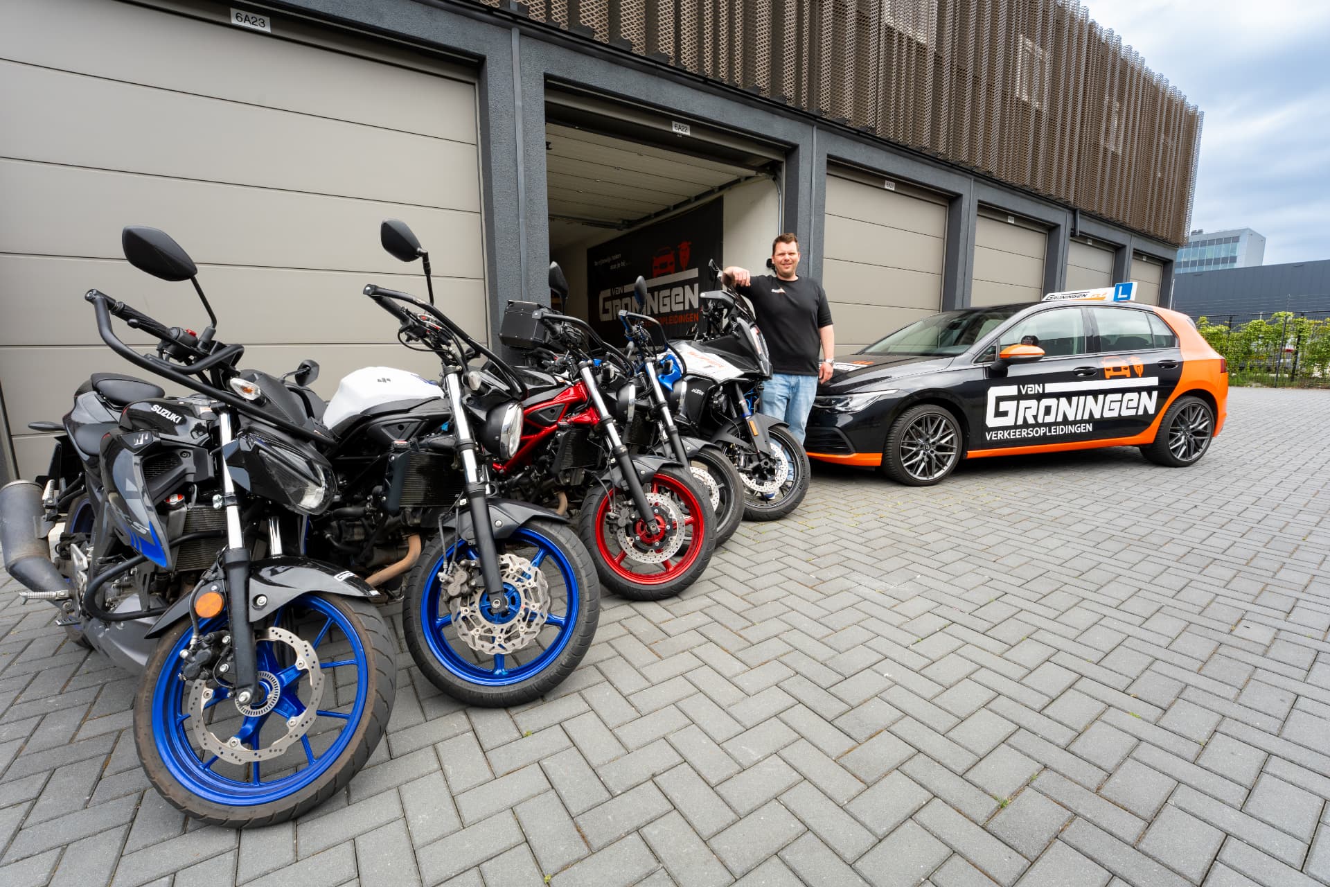 Stephan, oprichter en rij-instructeur, bij het wagenpark van Van Groningen Verkeersopleidingen