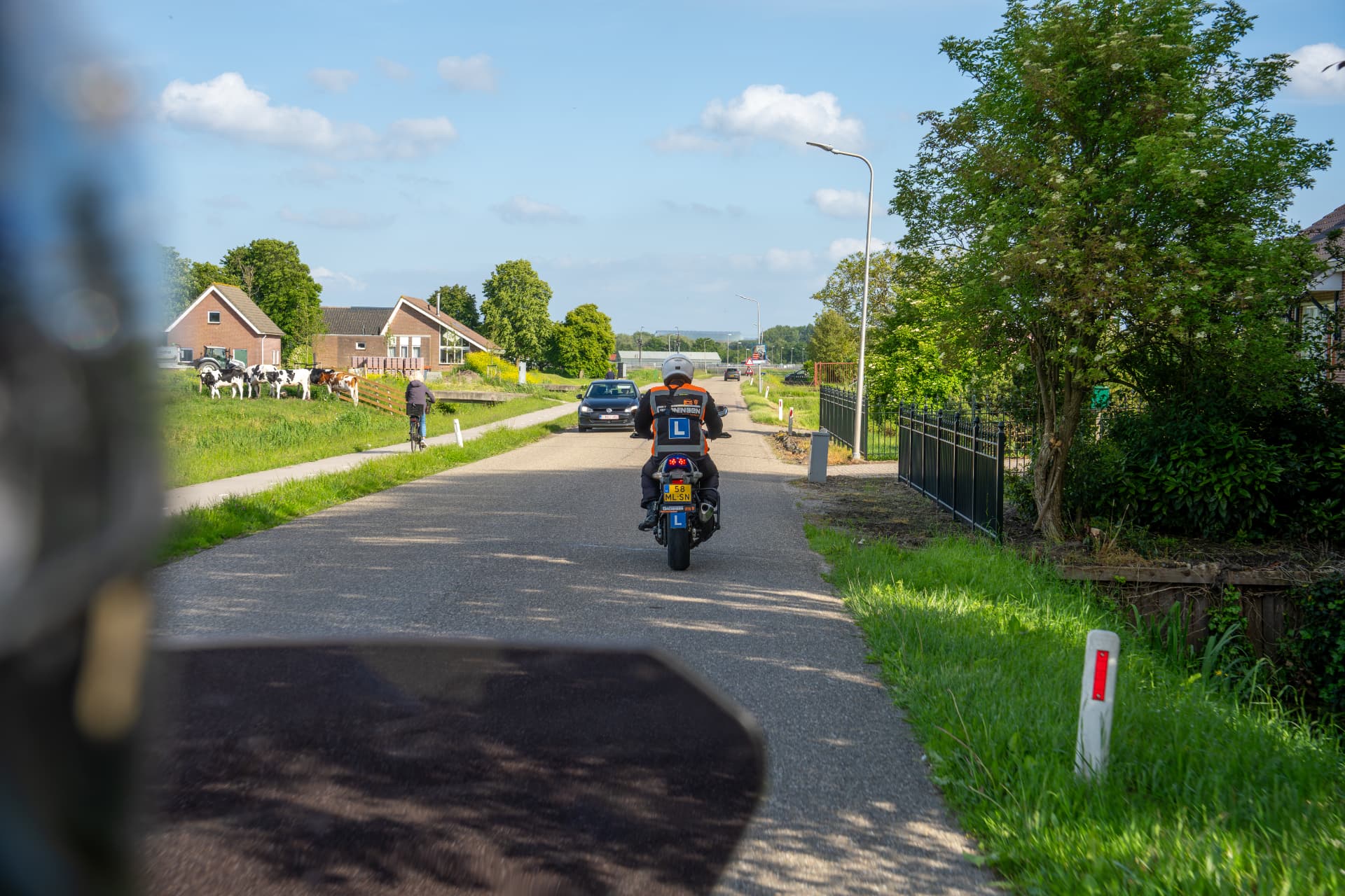 Motorleerling rijdt in het verkeer tijdens de motorrijles